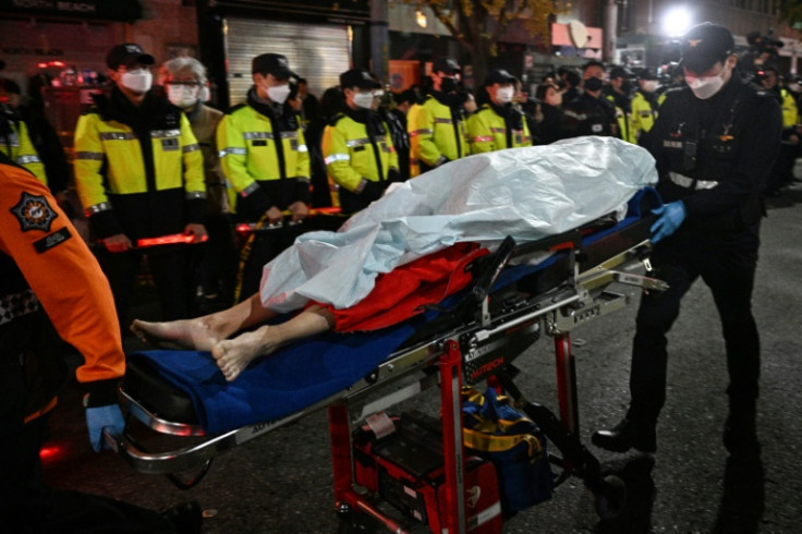 O corpo de uma vítima de uma debandada de Halloween é carregado em uma maca em Seul em 30 de outubro de 2022