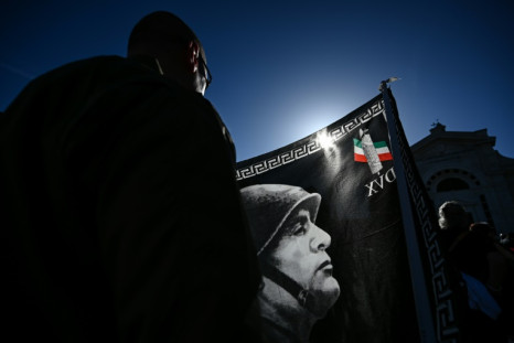 Um participante segura uma bandeira durante um comício que marca o centenário da Marcha sobre Roma, que inaugurou o fascismo