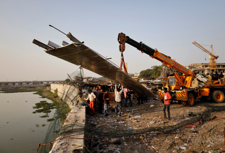 Pessoas removem detritos depois que uma ponte suspensa desabou na cidade de Morbi