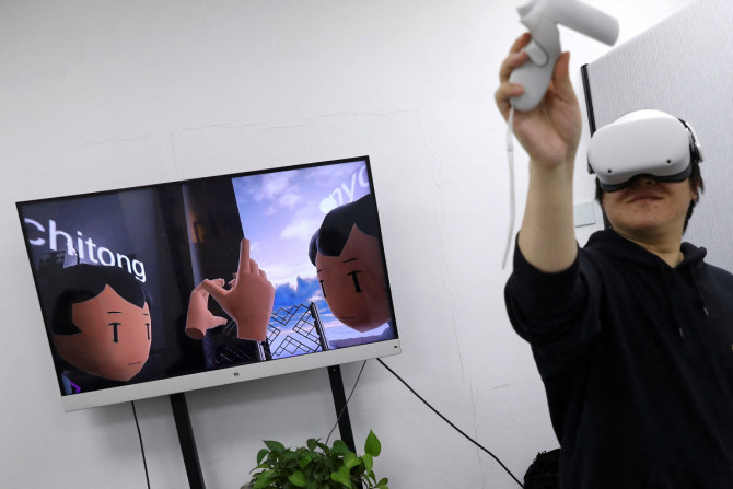 Pan Bohang, fundador da vHome, uma plataforma de jogos sociais VR, usando óculos VR cumprimenta um usuário durante uma reunião virtual, em um escritório em Pequim