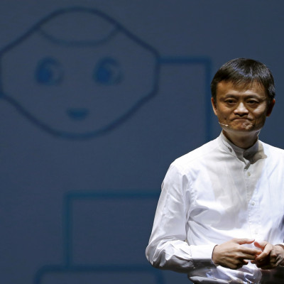 Jack Ma, fundador e presidente executivo do Alibaba Group da China, fala em frente a uma foto do robô semelhante a um humano do SoftBank chamado &#39;pimenta&#39; durante uma entrevista coletiva em Chiba