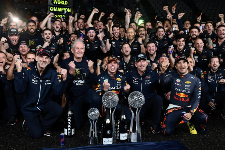 Max Verstappen (frente, centro) e toda a equipe e equipe de box da Red Bull comemoram a vitória consecutiva em campeonatos mundiais em Suzuka
