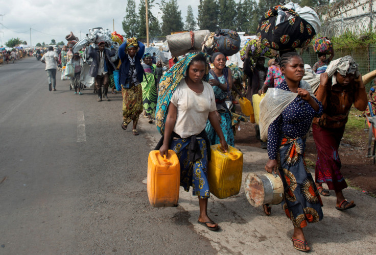 Civis congoleses deslocados internamente carregam seus pertences enquanto fogem de tensões renovadas de Kanyaruchinya para Goma