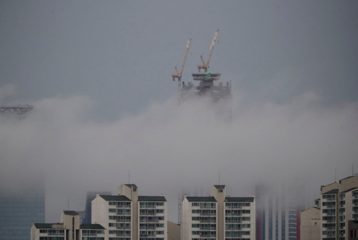 Um edifício que está atualmente em construção é visto acima de um nevoeiro durante um dia chuvoso em Seul