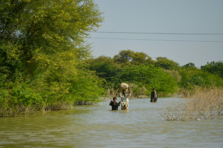Pessoas atravessam uma área inundada na província de Sindh, no Paquistão, em 27 de setembro de 2022