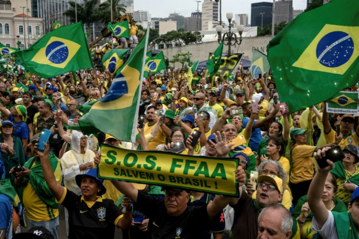 Apoiadores do presidente brasileiro Jair Bolsonaro seguram cartazes pedindo intervenção militar durante uma manifestação contra o resultado do segundo turno que ele perdeu para Luiz Inácio Lula da Silva