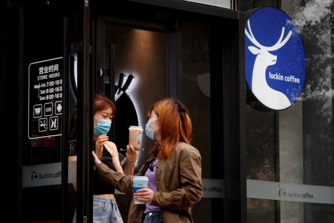 Mulheres saem de uma loja da rede de cafeterias chinesa Luckin Coffee em Pequim