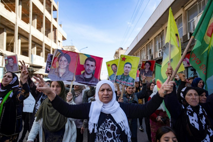 Manifestantes sírio-curdos em Qamishli levantam fotos de pessoas mortas em ataques turcos