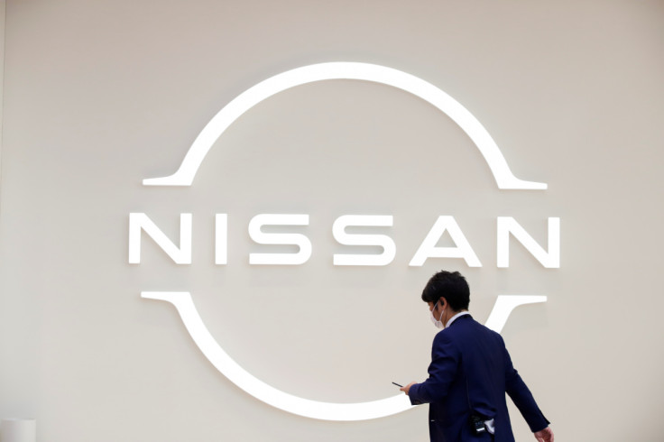 Homem caminha em frente ao logotipo da Nissan na Nissan Gallery em Yokohama