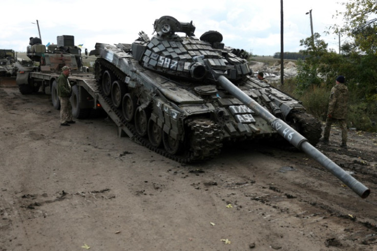 Um tanque russo T-72 é carregado em um caminhão por soldados ucranianos fora da cidade de Izyum em 24 de setembro de 2022
