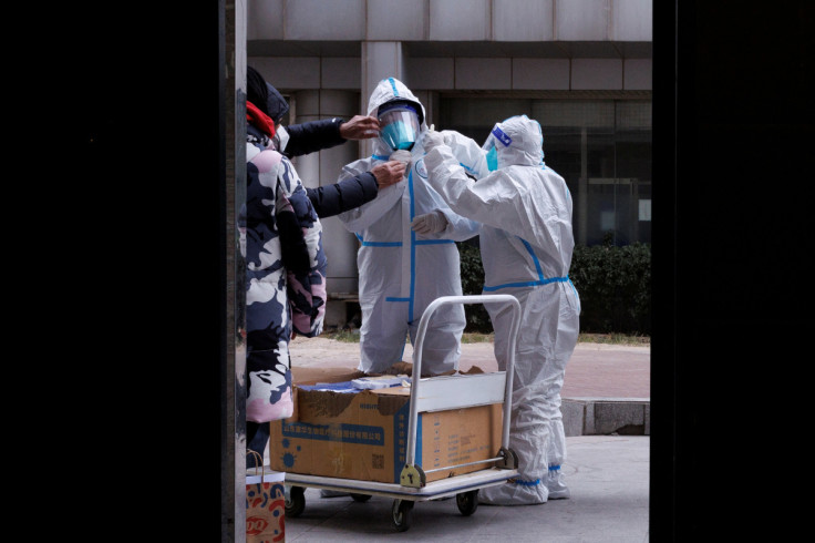 Trabalhadores de prevenção de pandemia em trajes de proteção se preparam para entrar em um prédio de apartamentos que foi bloqueado enquanto os surtos de doença por coronavírus (COVID-19) continuam em Pequim