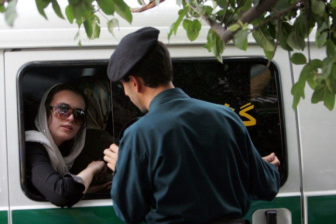 Um oficial iraniano (R) fala com uma mulher presa por usar roupas &#39;inadequadas&#39; em Teerã, em 23 de julho de 2007