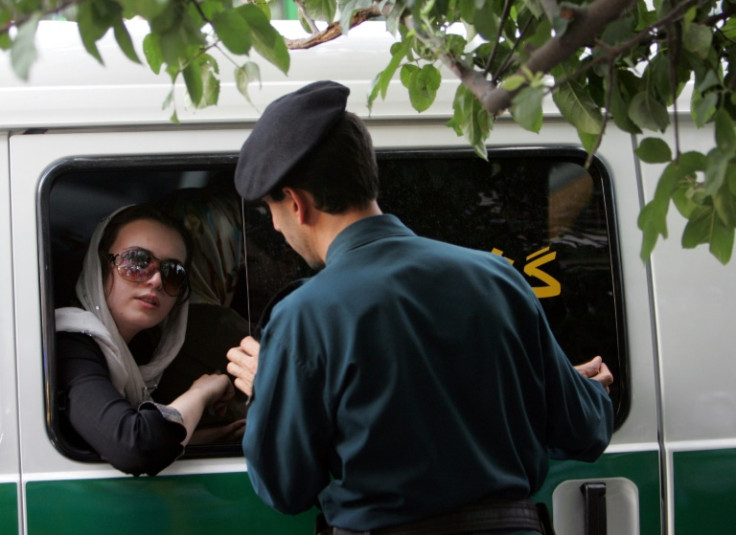 Um oficial iraniano (R) fala com uma mulher presa por usar roupas &#39;inadequadas&#39; em Teerã, em 23 de julho de 2007