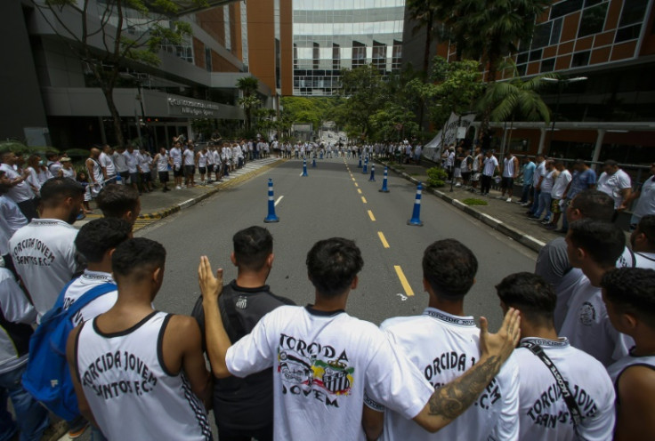 Centenas de torcedores de futebol participaram de uma vigília em 4 de dezembro de 2022 do lado de fora da clínica de São Paulo, onde o astro brasileiro Pelé luta contra uma infecção respiratória.
