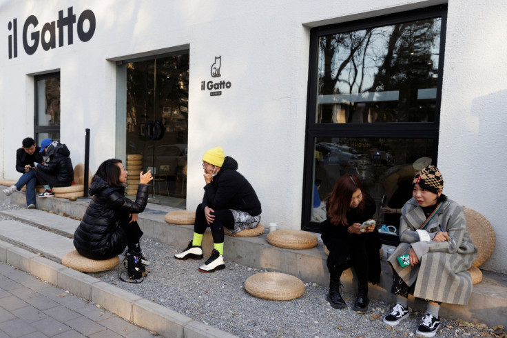 As pessoas sentam-se do lado de fora de um café depois que algumas restrições foram suspensas, enquanto os surtos de doença por coronavírus (COVID-19) continuam em Pequim