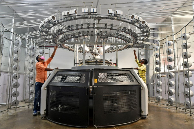 Trabalhadores operam uma máquina de tricô em uma fábrica têxtil da Texport Industries na cidade de Hindupur, no estado de Andhra Pradesh, no sul da Índia, em 9 de fevereiro de 2022.