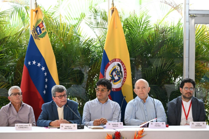Os comandantes guerrilheiros do Exército de Libertação Nacional da Colômbia (ELN) Aureliano Carbonell (E) e Pablo Beltran (2-E) se reúnem com a delegação do governo colombiano Danilo Rueda (C), Otty Patino (2-R) e Ivan Cepeda (R) em Caracas, 12 de dezembr