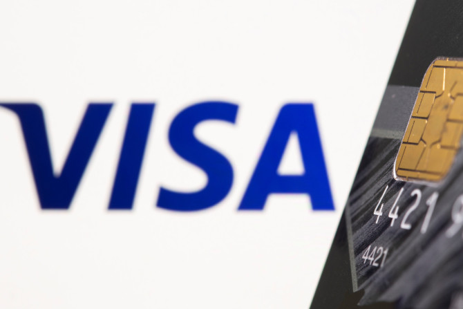 O cartão de crédito é visto na frente do logotipo da Visa exibido nesta ilustração