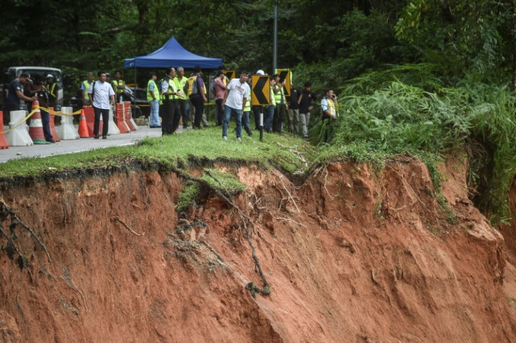 Equipes de resgate vasculharam o terreno lamacento em busca de sobreviventes e corpos enquanto o número de mortos em um deslizamento de terra em um acampamento na Malásia subiu para 21