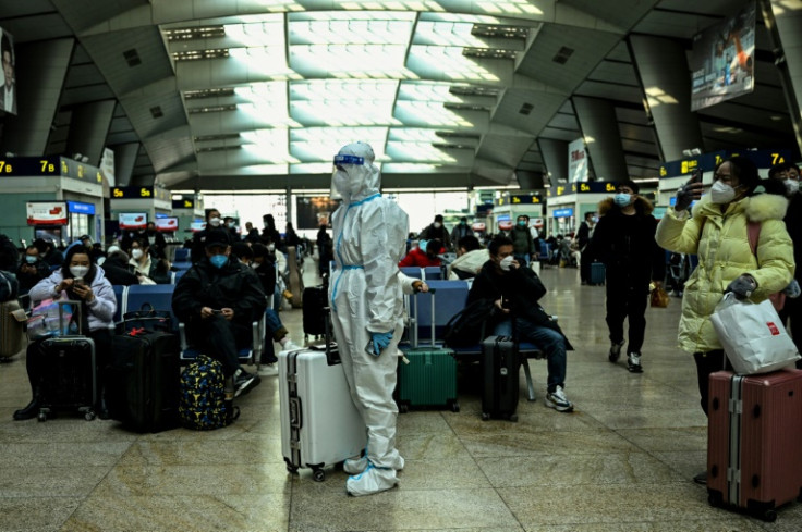 Um passageiro usando equipamento de proteção é visto em uma estação de trem em Pequim em 28 de dezembro