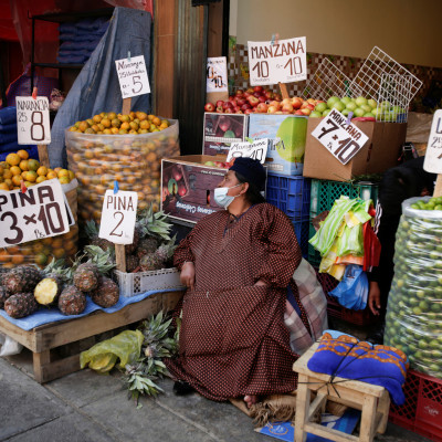 Vendedores de frutas conversam em um mercado de rua em La Paz