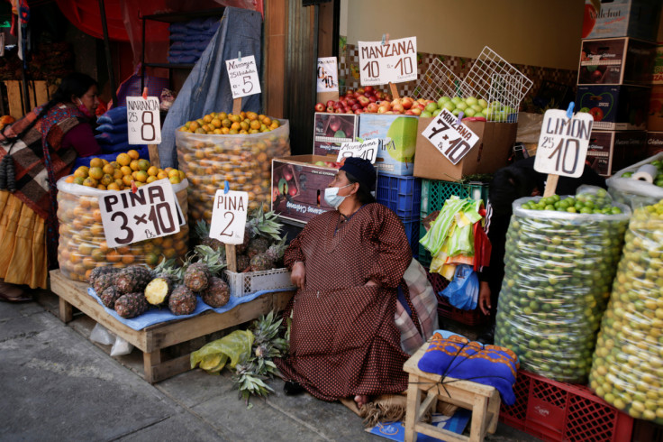 Vendedores de frutas conversam em um mercado de rua em La Paz
