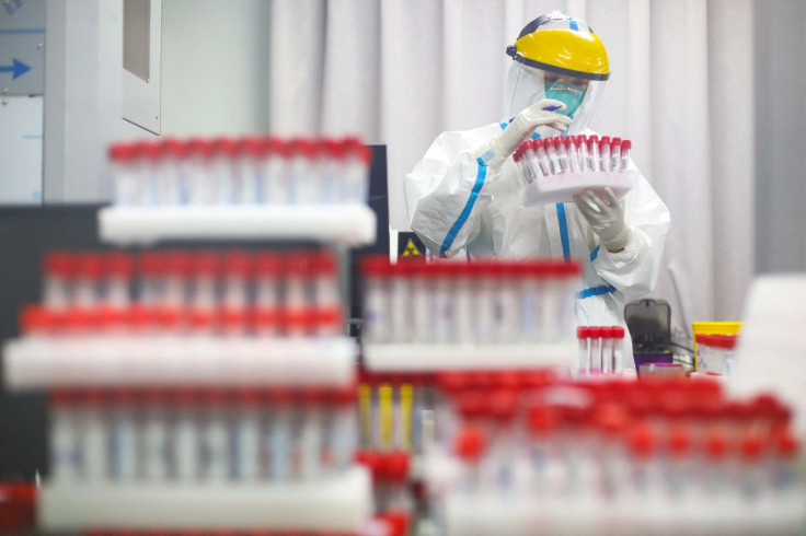 Uma equipe médica em traje de proteção trabalha em um laboratório de teste de ácido nucleico do Primeiro Hospital de Nanjing após um teste em massa em toda a cidade para a doença de coronavírus (COVID-19) em Nanjing, província de Jiangsu, China, 24 de jul