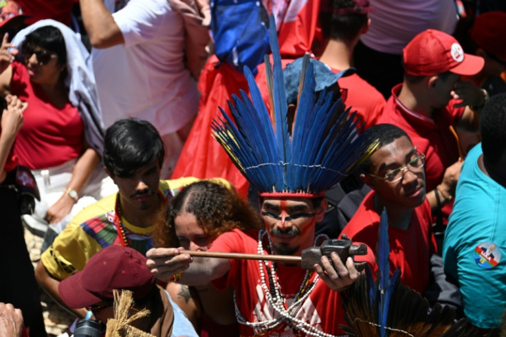 Um indígena com cocar tradicional se junta à multidão de inauguração