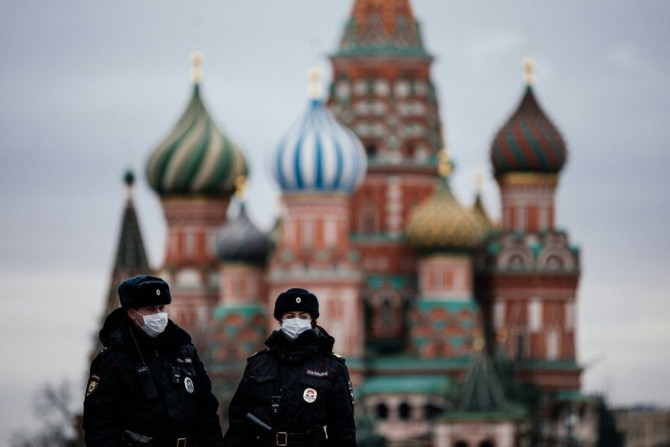 Policiais russos patrulham uma praça vermelha deserta em frente à Catedral de São Basílio, em Moscou, enquanto a capital e outras partes da Rússia entram em confinamento para conter o novo coronavírus.