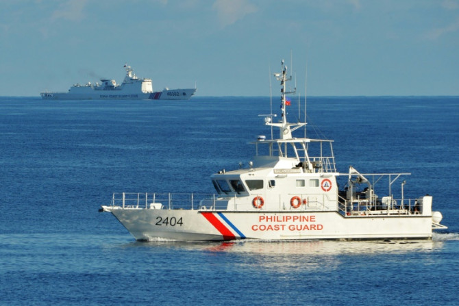 Um navio da guarda costeira das Filipinas (R) passa por um navio da guarda costeira chinesa perto de Scarborough Shoal no Mar da China Meridional em 2019