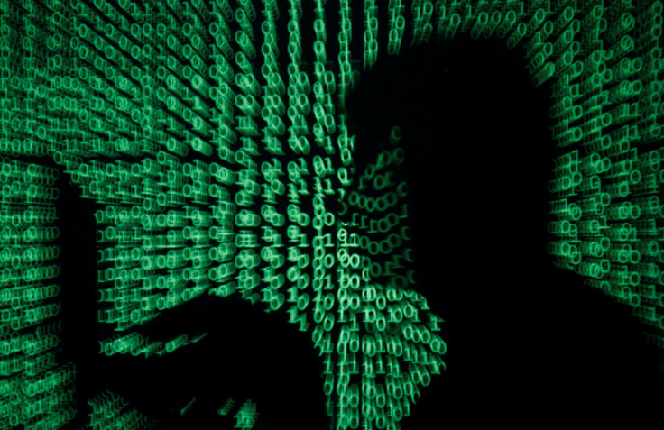 O homem segura o computador portátil enquanto o código cibernético é projetado nele nesta imagem ilustrativa