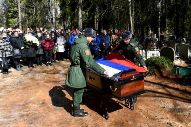 Soldados cobrem o caixão de Avrov com a bandeira nacional - as mortes russas exatas não são conhecidas, com a última contagem oficial de 1.351 dada em 25 de março.