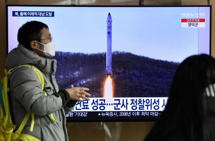 Um homem passa por uma tela de televisão mostrando um noticiário com imagens de arquivo de um teste de míssil norte-coreano, em uma estação ferroviária em Seul, em 31 de dezembro de 2022, depois que a Coreia do Norte disparou três mísseis balísticos de cu