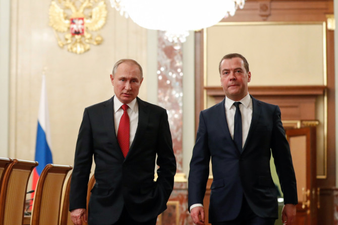 O presidente russo Putin e o primeiro-ministro Medvedev falam antes de uma reunião com membros do governo em Moscou