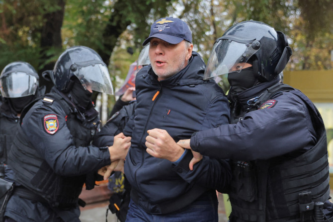 Policiais russos detêm uma pessoa durante uma manifestação em Moscou
