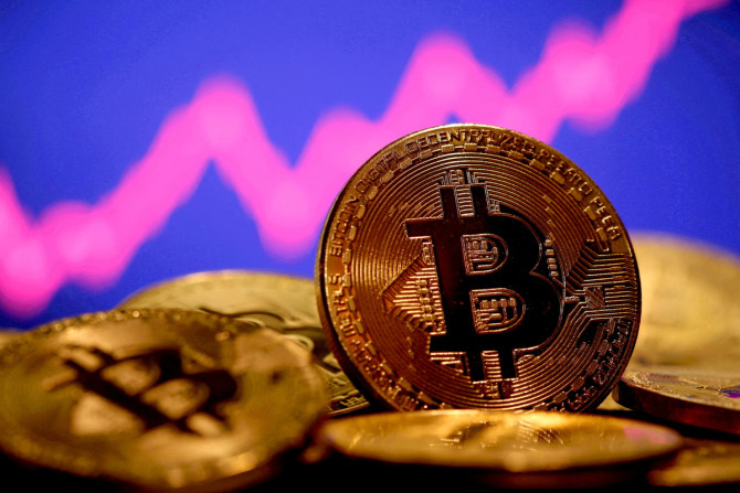 Uma representação da moeda virtual Bitcoin é vista na frente de um gráfico de ações nesta ilustração