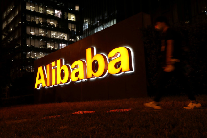 Homem passa por um logotipo do Grupo Alibaba em seu prédio de escritórios em Pequim