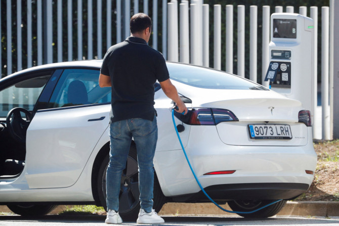 Um homem remove um cabo após carregar um carro elétrico da Tesla em Sant Cugat del Valles, perto de Barcelona