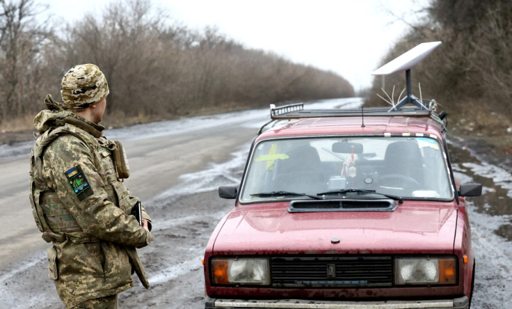 Um soldado ucraniano fica ao lado de um veículo que carrega um sistema de internet via satélite Starlink perto da linha de frente