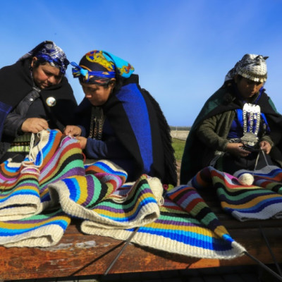 Mulheres indígenas Mapuche do Chile tecem em um tear; um novo estudo ligou uma antiga linhagem asiática com os primeiros americanos