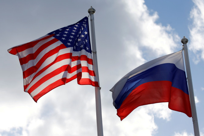 Bandeiras dos estados da Rússia e dos EUA tremulam perto de uma fábrica em Vsevolozhsk