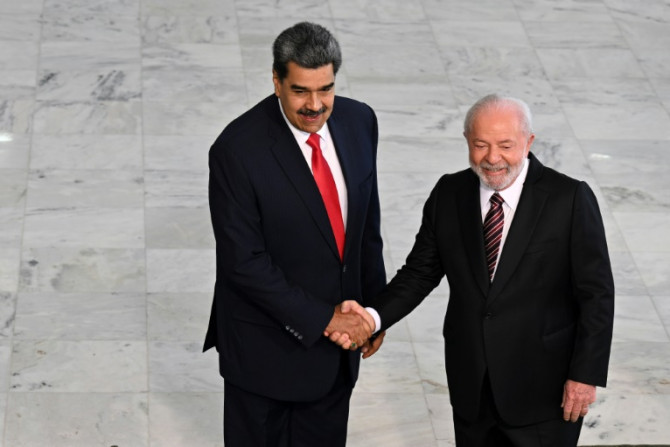 O presidente da Venezuela, Nicolás Maduro (E), e o presidente do Brasil, Luiz Inácio Lula da Silva, apertam as mãos durante uma cerimônia de boas-vindas no palácio presidencial em Brasília