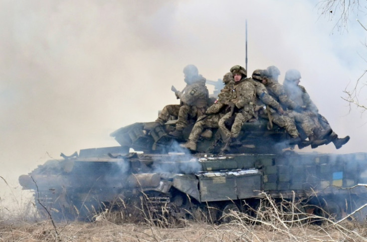 Soldados ucranianos sentam-se em cima de tanques de batalha implantando cortinas de fumaça enquanto se juntam a exercícios militares