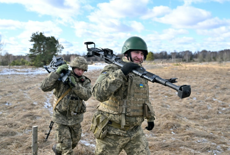 Soldados ucranianos carregam uma metralhadora pesada enquanto treinam perto da zona de exclusão de Chernnobyl