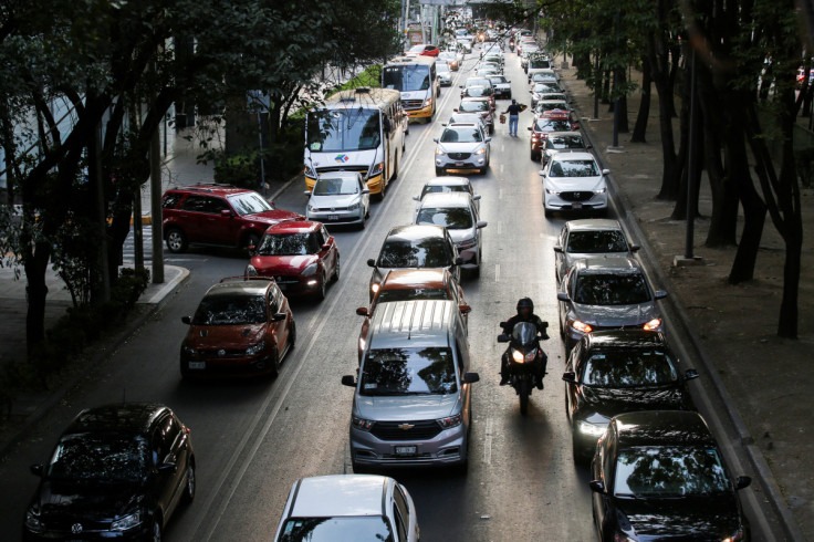 Um homem anda de moto na frente de uma fila de carros no trânsito durante a hora do rush na Cidade do México