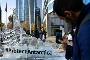 Transeuntes tiram fotos de uma escultura de gelo representando um krill em Santiago em 19 de junho de 2023, enquanto a Comissão para a Conservação dos Recursos Vivos Marinhos Antárticos se reúne para discutir três novas propostas de áreas marinhas protegi