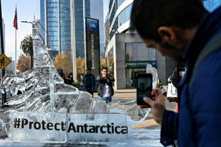 Transeuntes tiram fotos de uma escultura de gelo representando um krill em Santiago em 19 de junho de 2023, enquanto a Comissão para a Conservação dos Recursos Vivos Marinhos Antárticos se reúne para discutir três novas propostas de áreas marinhas protegi