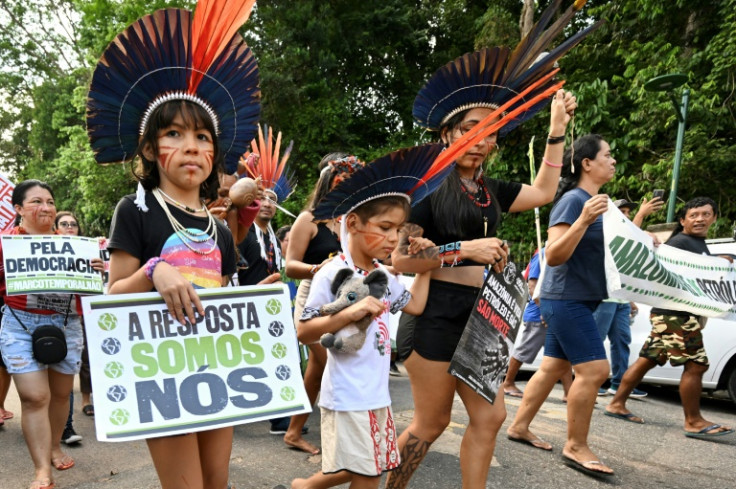 Ativistas indígenas da Amazônia e ativistas climáticos demonstram à margem de uma cúpula em Belém, Brasil, sobre como salvar as florestas tropicais do mundo