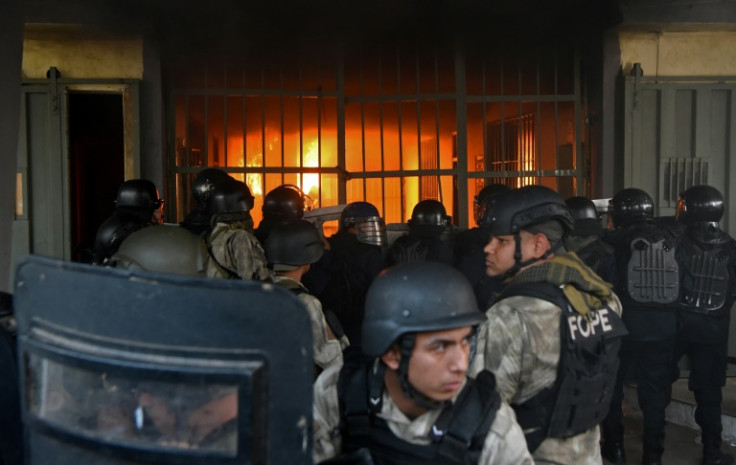 Forças de segurança se reúnem em frente ao presídio de Tacumbu enquanto um incêndio queima em seu interior